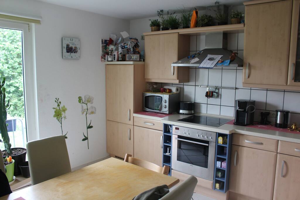 Küche mit Spülmaschine und Ceranherd. Tisch mit Stühlen für 5 Personen. Kinderstuhl ist vorhanden.