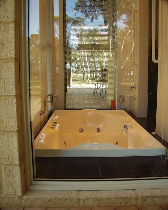 Large bathroom with spa bath, shower and heated towel railings.