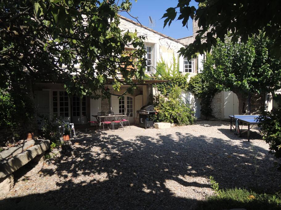 La maison, la cour avec la pergola, le barbecue et le tennis de table.
The house, the courtyard with pergola, barbecue and Ping-Pong table.