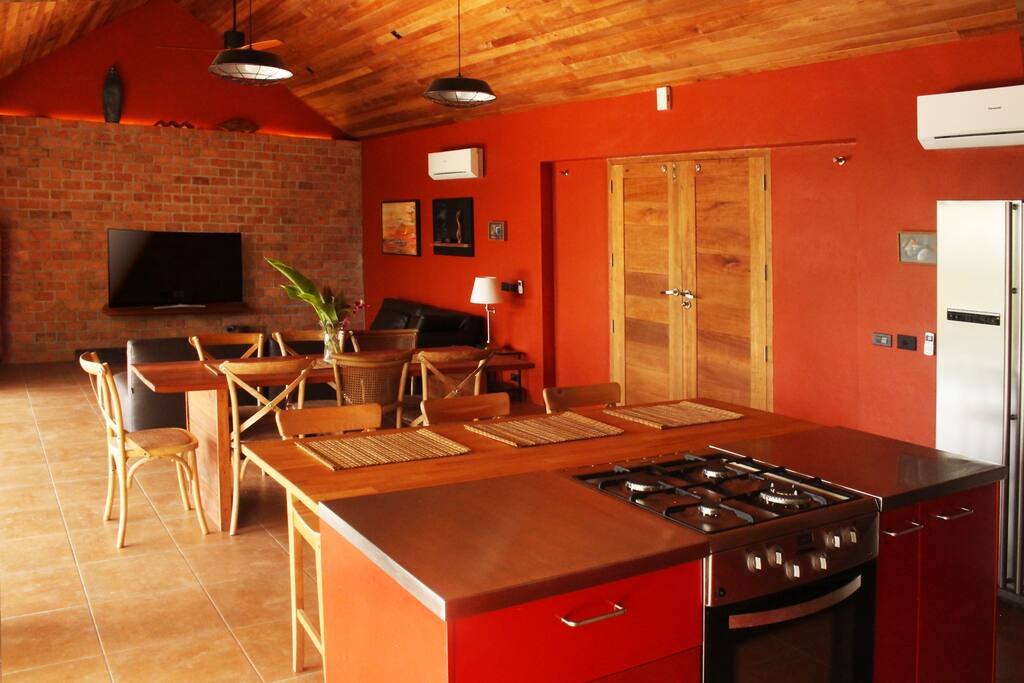 The living area - the long red room opening to the pool and view, with leather seating area.