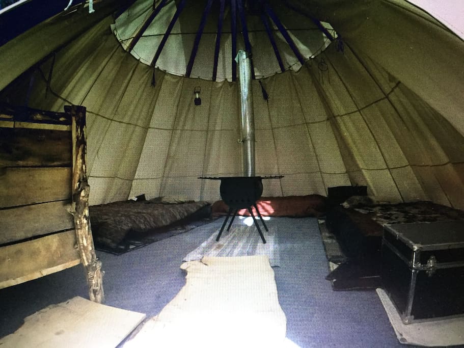 Carpet, Rugs, lighting, woos burning stove, 3 blow up mattresses and bedding. On the wood shelves there are pans, cups, plates, eating and cooking utensils.
