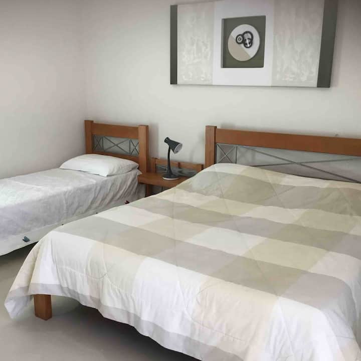 Chumba kikubwa + Roshani - 28 m2
Mlango/kaunta iliyo na skrini.
Kiyoyozi.
Feni ya Dari.
Kitanda 1 cha Queen kitanda
1 cha mtu mmoja 
TV 49’. 

