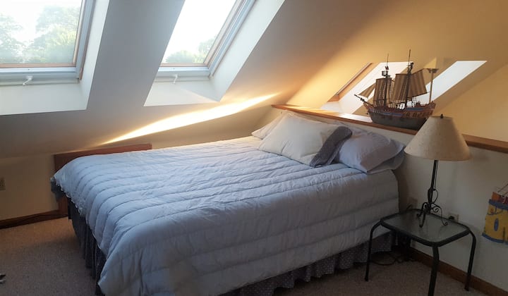 سرير بحجم كوين في غرفة النوم العلوية للشقة.