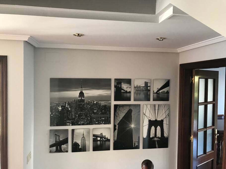 Hall de entrada con cuadros de NY, y puerta de paso al salón-comedor.