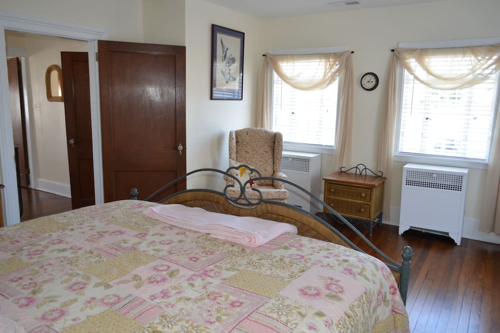 King bed with sitting area, dressers and closet.