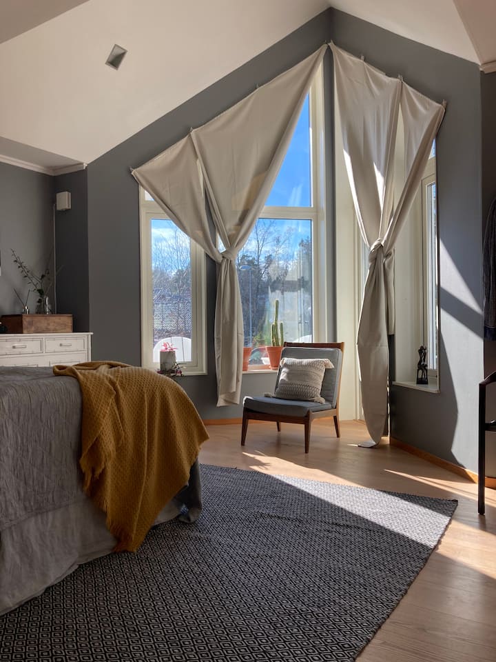 Dhomë gjumi master me seksione dritaresh të larta 5 metra dhe dalje në oborr.