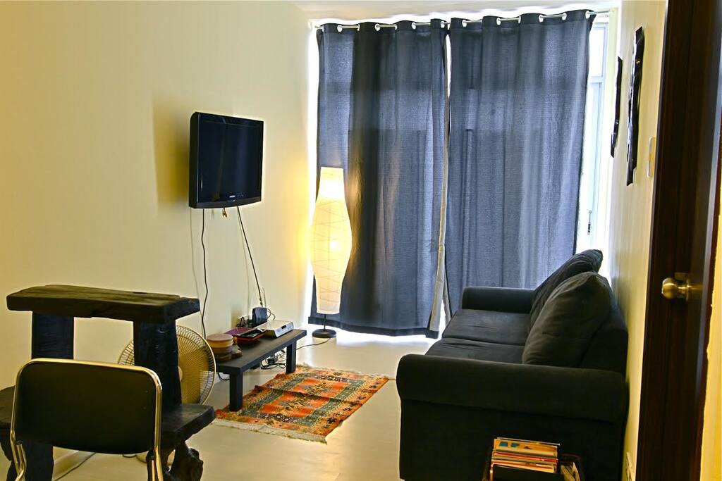 Living room. Behind the curtains is a balcony that overlooks the pool