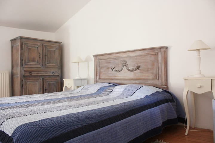 غرفة نوم متوسطة بسرير مزدوج 160 × 200 وخزانة ملابس وطاولات بجانب السرير.