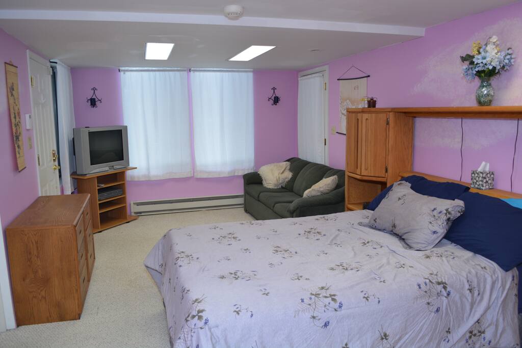 The couch provides a view of a private yard, and curtains offer cozy privacy.