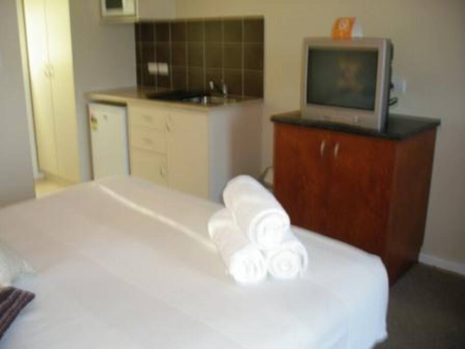 TV and small kitchenette with microwave, kettle, toaster, coffee and tea, and a large electric fry pan