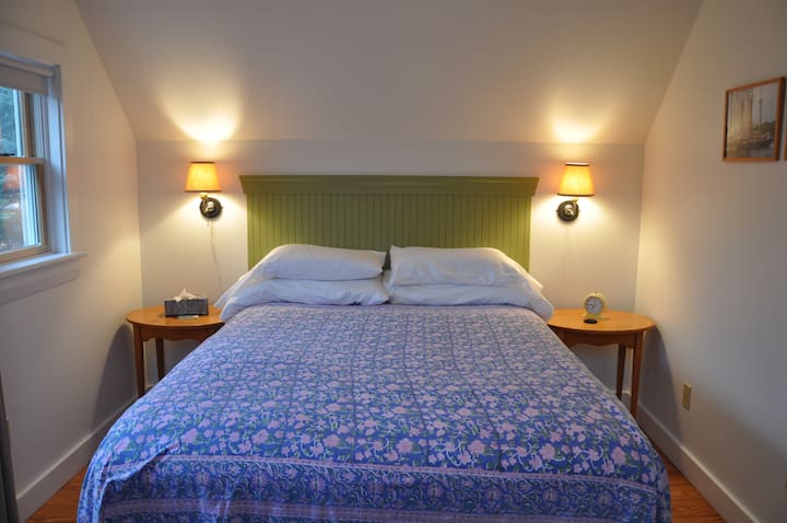 The queen sized bed has comfortable cotton linens and a flat screen tv.