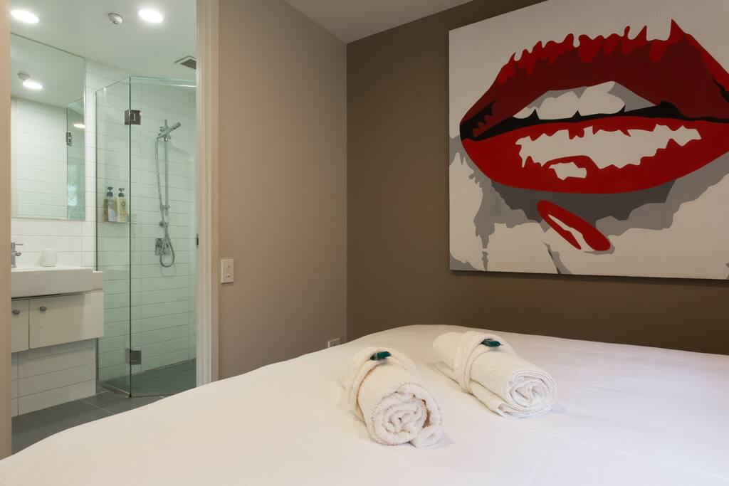 Bedroom with King bed (NZ), built in wardrobe and side tables.
