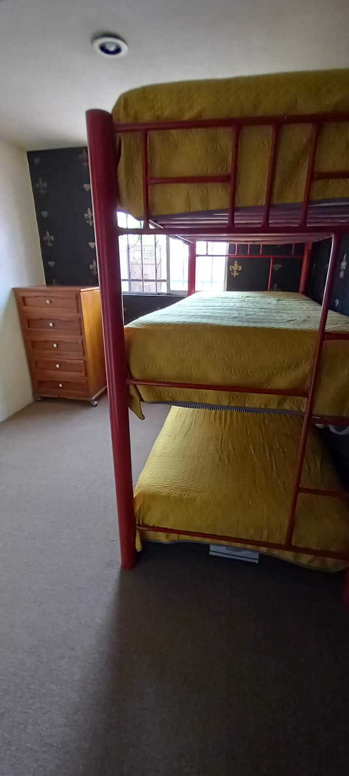 الغرفة الأولى مع سرير ثلاثي واحد ودرج وخزانة ريفية 