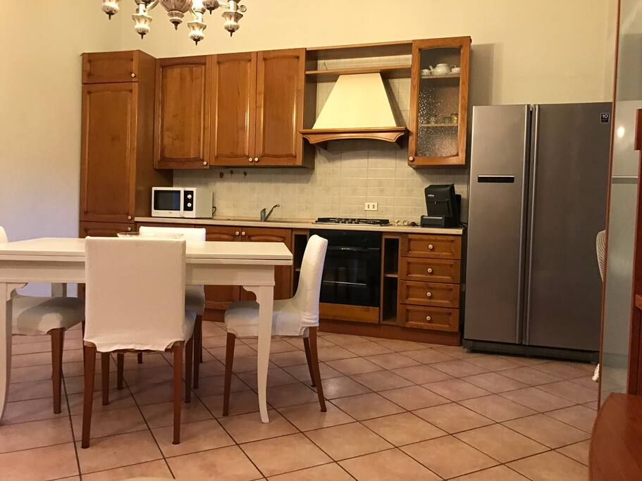 Cucina munita di ampio frigorifero, freezer, microonde, gas, forno, tavolo, stoviglie (piatti, bicchieri, posate)e caffettiera