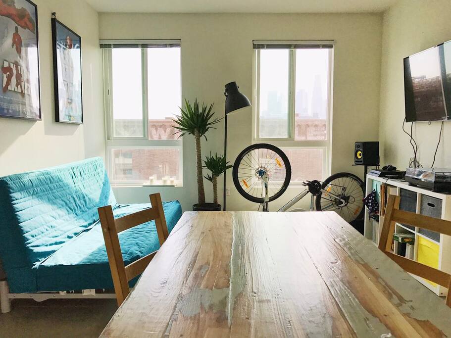 Living room with a double sofa, wooden table, TV, turntable, loudspeakers, PS4
