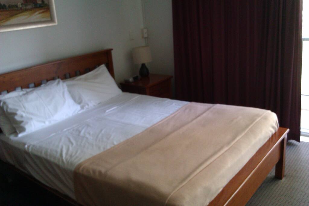 A queen bed in the main bedroom