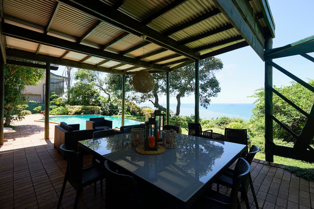 THE LARGE, ROOFED PATIO, POOL AND AWESOME SEA VIEW -- SHOWING THE DINING AREA