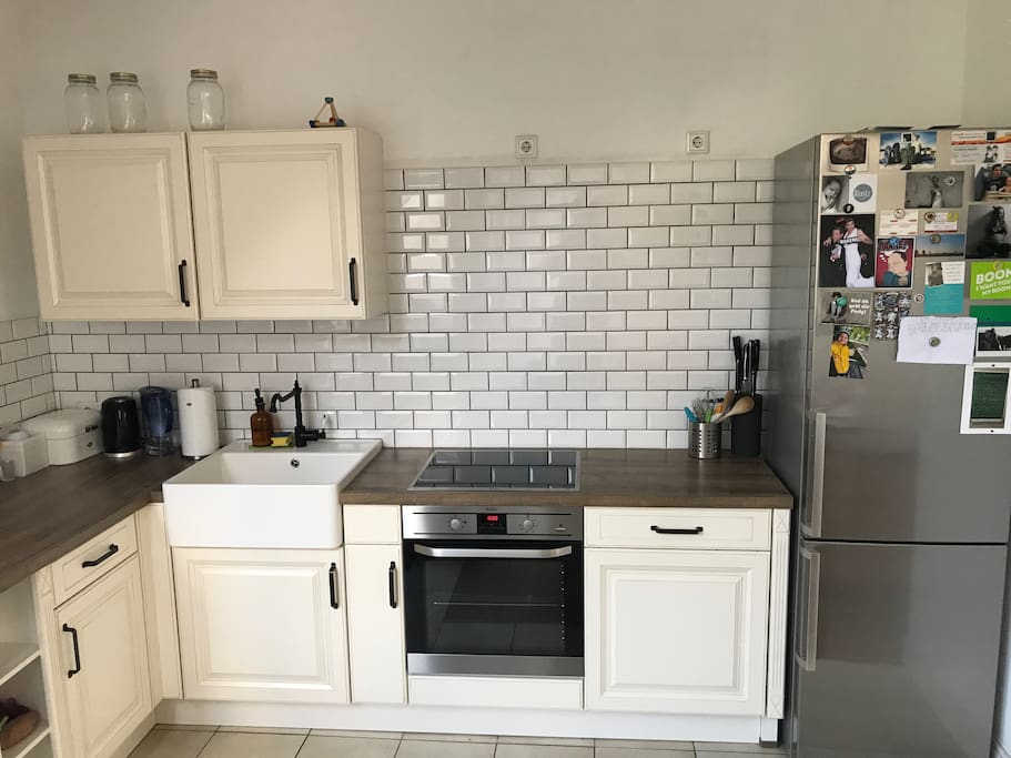 Kochbereich mit Induktions-Kochfeldern, Ofen, Spülmaschine, Kühlschrank, Gefrierschrank und Spülstein