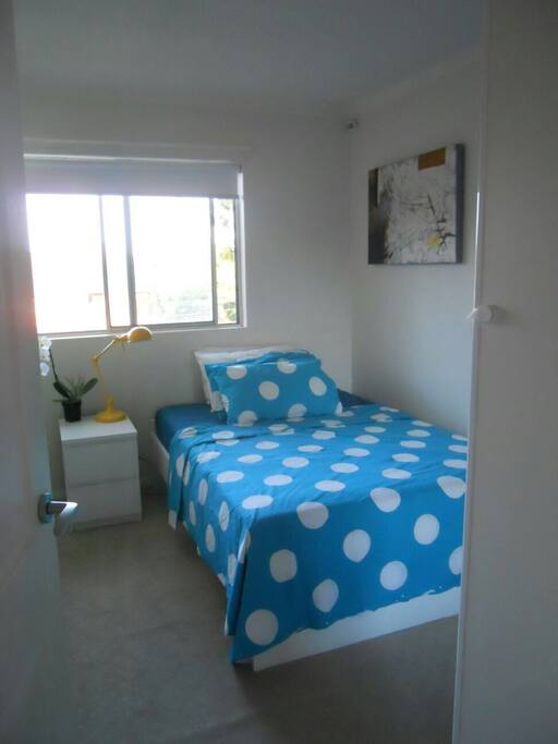 Cozy bedroom with built-in wardrobe and a glimpse of the city view