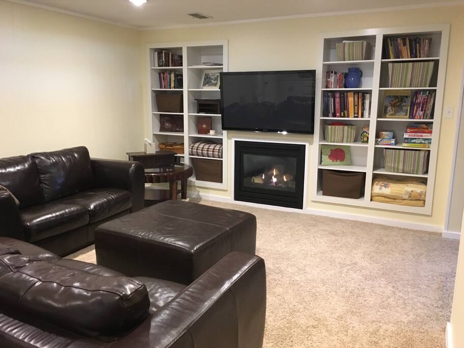 Downstairs living area with leather sofas & 50" screen TV (Netflix, Amazon).
