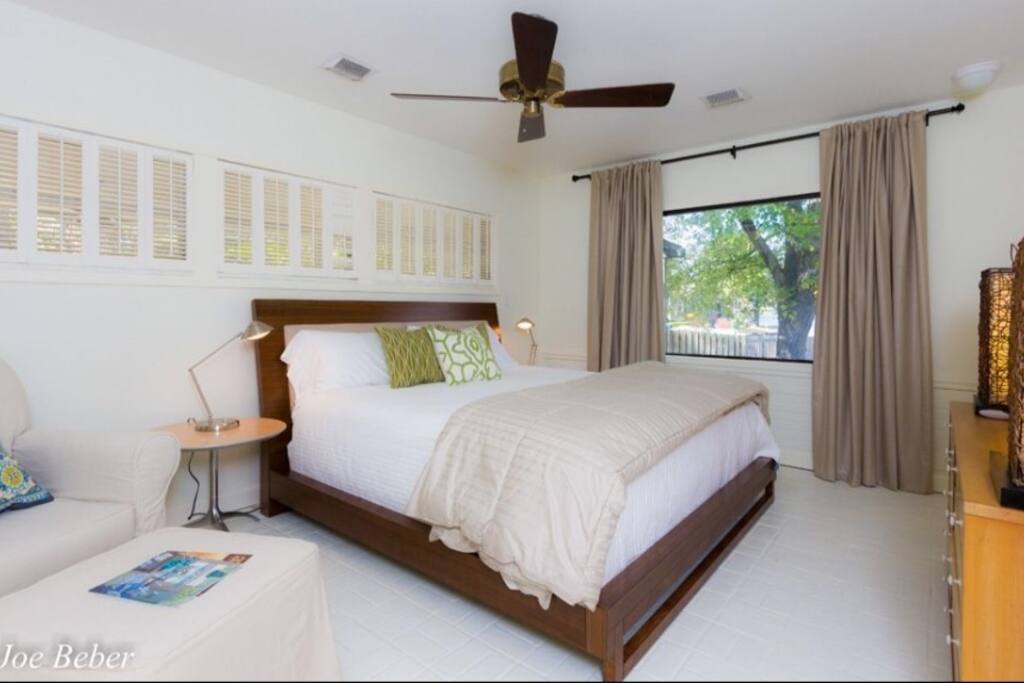 Smaller bedroom with bath has flat screen tv and water view.