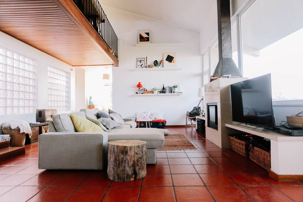 Salón con chimenea, amplios ventanales y vistas al mar.