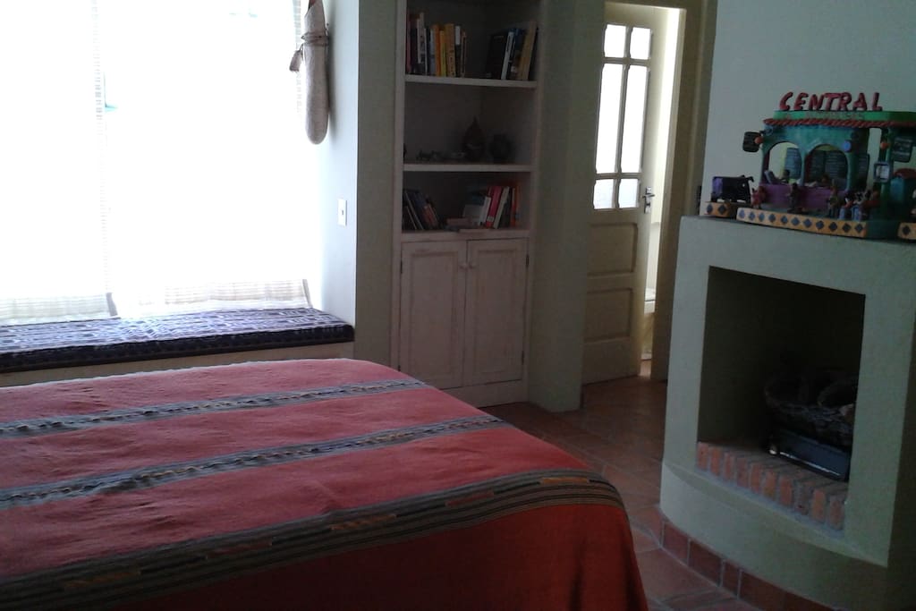 bedroom with fireplace, window seat, entry door to toilet
