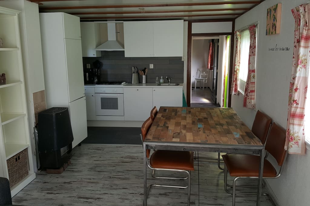 Keuken met vaatwasser en oven. De zitruimte zit er aan vast hier bevindt zich ook de slaapbank voor 2 personen.
