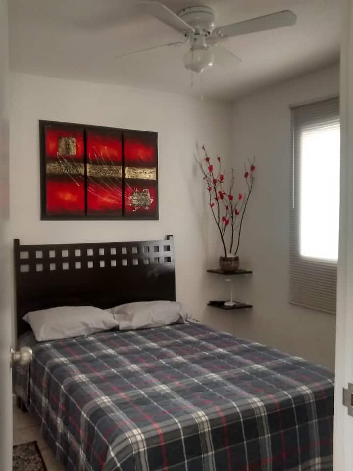 ห้องนอนใหญ่มีพัดลมเพดานตู้เสื้อผ้าขนาดใหญ่เคเบิลทีวีตู้เสื้อผ้าขนาดใหญ่และหน้าต่างพร้อมมุ้งกันยุง