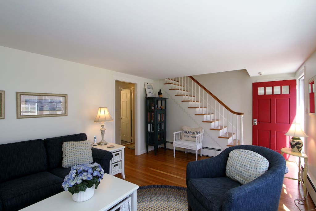 Enter into the main living area, which features original hardwood floors and stair banister.