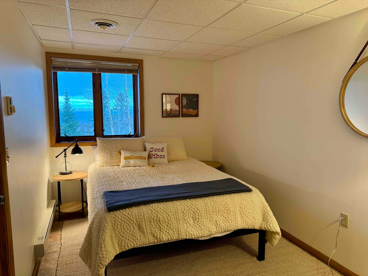 Kjo dhomë gjumi në katin e poshtëm ka një krevat dopio "queen" dhe komodina të dyfishta. Dritaret e ekranit janë të hapura për ajër të pastër dhe tinguj nga përroi. Nxehtësia e bazamentit moderon temperaturën. Dollap i plotë me shtroja, batanije dhe jastëkë shtesë. Banjë poshtë korridorit.