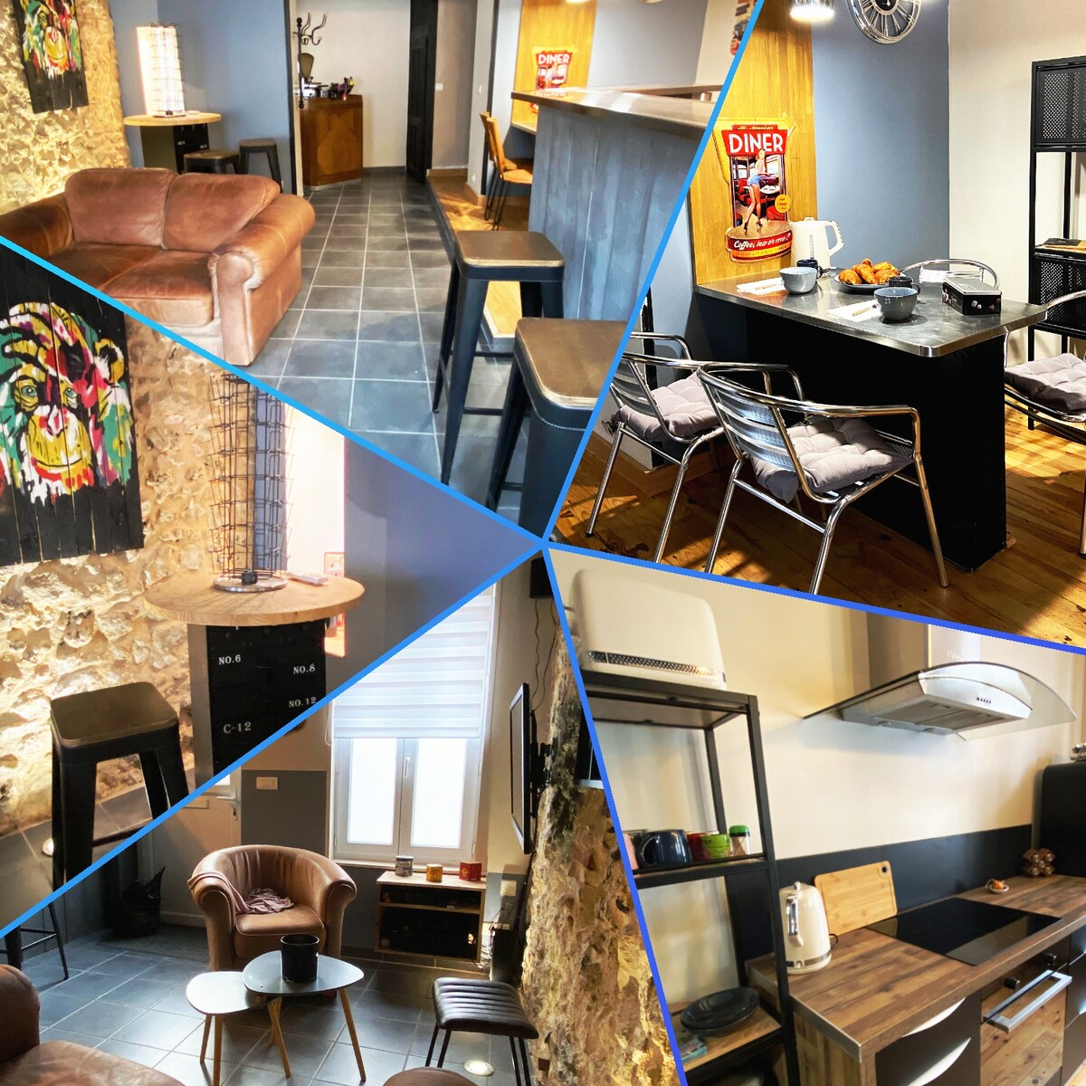 A cozy living area features vintage-inspired furnishings, including a spacious leather sofa and sleek metal bar stools at a counter. A small kitchen area is equipped with essential appliances, while decorative artwork adds character to the space. Textured stone walls enhance the unique ambiance.
