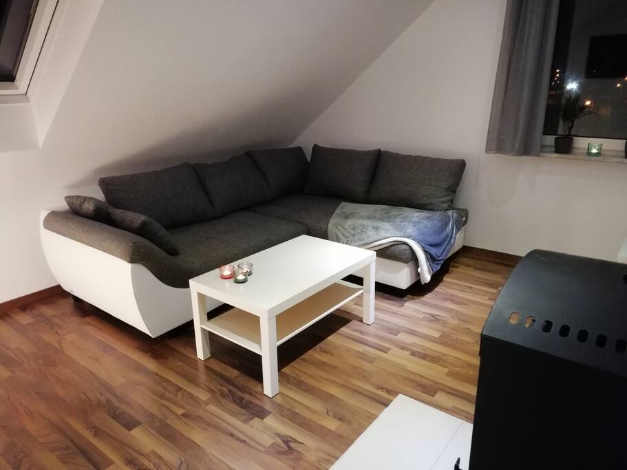 Wohnzimmer mit Schlafcouch und Fußbodenheizung
