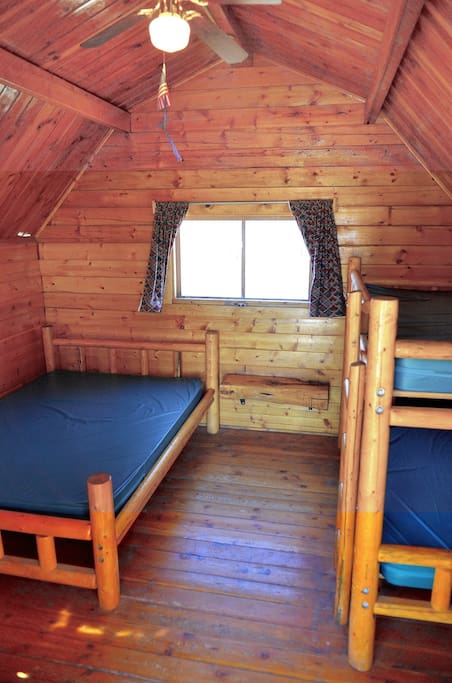 One room cabin with one double bed and a set of bunk beds.
