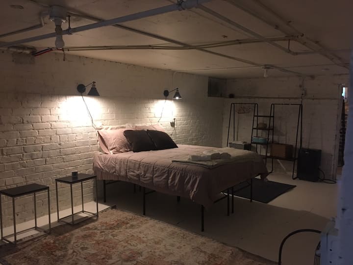 Cama tamaño queen nueva, con dos mesas laterales y luces laterales.