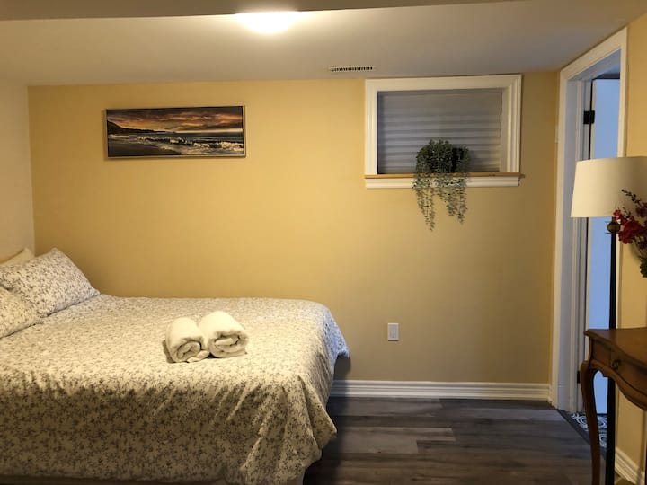 Un dormitorio con una cama tamaño queen y un baño privado en la planta inferior