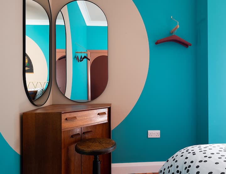 Dressing table, double mirrors and clothes hanging space in the colourful twin bedroom.