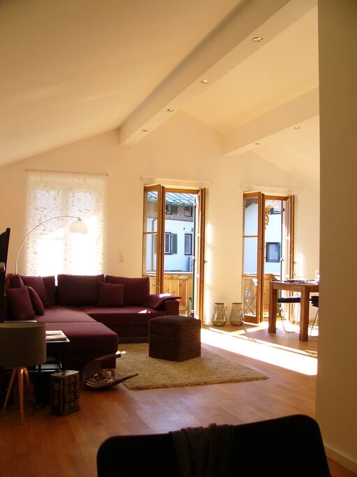 loftartiger hoher Wohnraum mit Sofaecke und Tisch