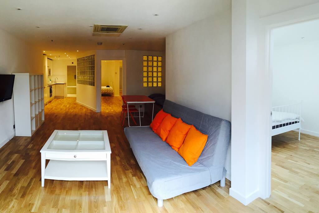 Through the lounge to the back bedroom (right), front bedroom (far right), and kitchen and bathroom (back left)