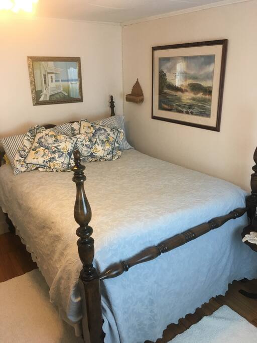 Antique four poster double bed room is decorated in shades of blues and pale yellow original artwork is on the walls from host travels to Central America and New England