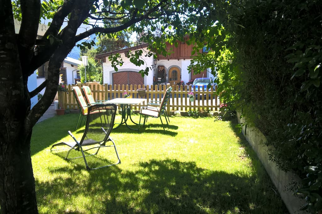 Sitzgelegenheiten und ein Liegestuhl im Garten laden zum Verweilen ein