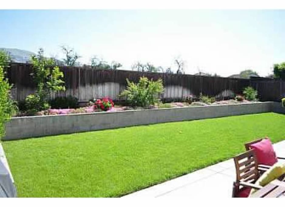 Nice backyard with a grass grill and some patio furniture