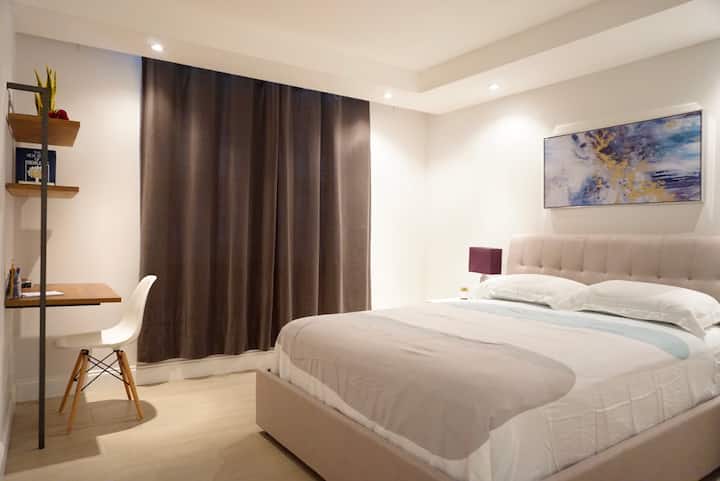 ห้องนอนสไตล์มินิมอลที่เงียบสงบพร้อมเตียงควีนไซส์ 