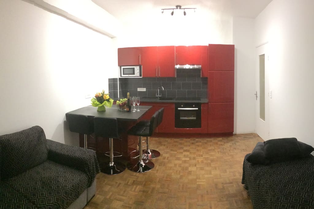 Main room with americain kitchen has a comfortable sofe, TV and Air Conditionning