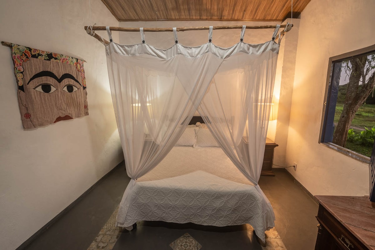 Veľká spálňa s manželskou posteľou a moskytiérou.