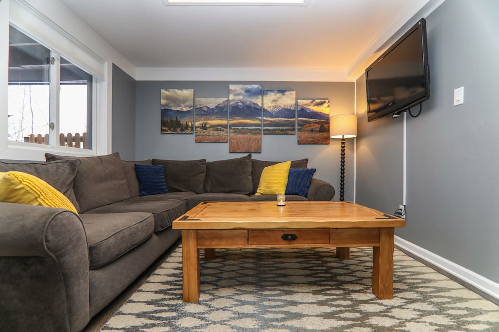 Living room with large comfy couch, TV, AppleTV