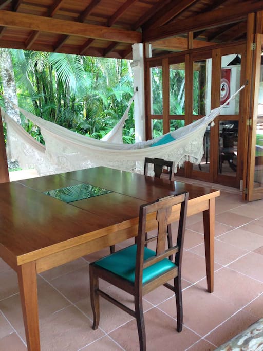 Terraço com redes e mesa de almoço