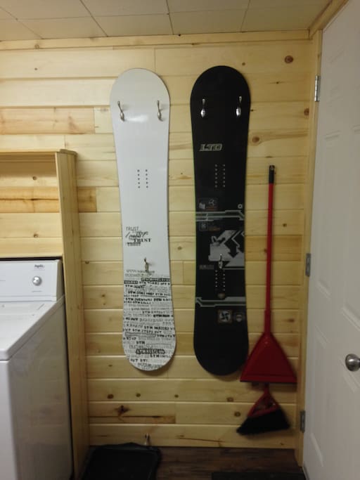 Snowboards with hooks for coats and stuff at door.