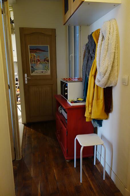 Le couloir entre Le salon, la cuisine et la salle de bain. La porte de la chambre est sur le mur de gauche