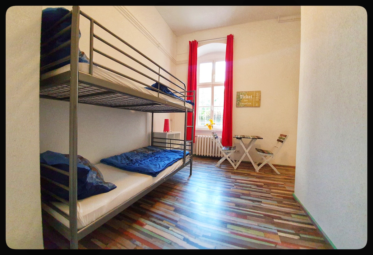 Doppelzimmer mit Etagenbett und kleinem Kühlschrank.